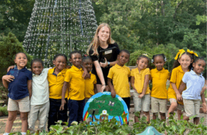 Experience UGA volunteer posing with 10 CCSD students