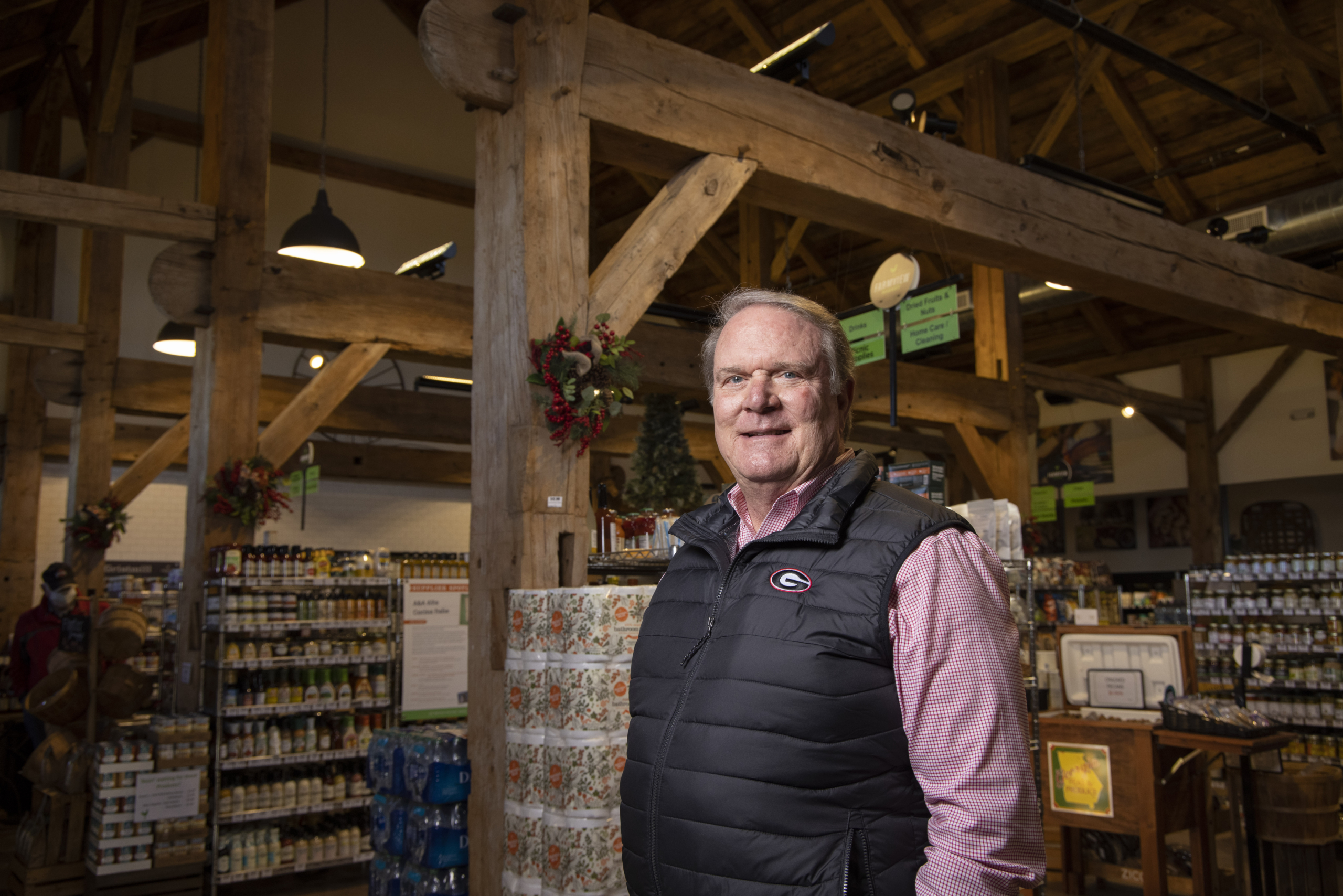 A smiling man stands in a rustic storefront.