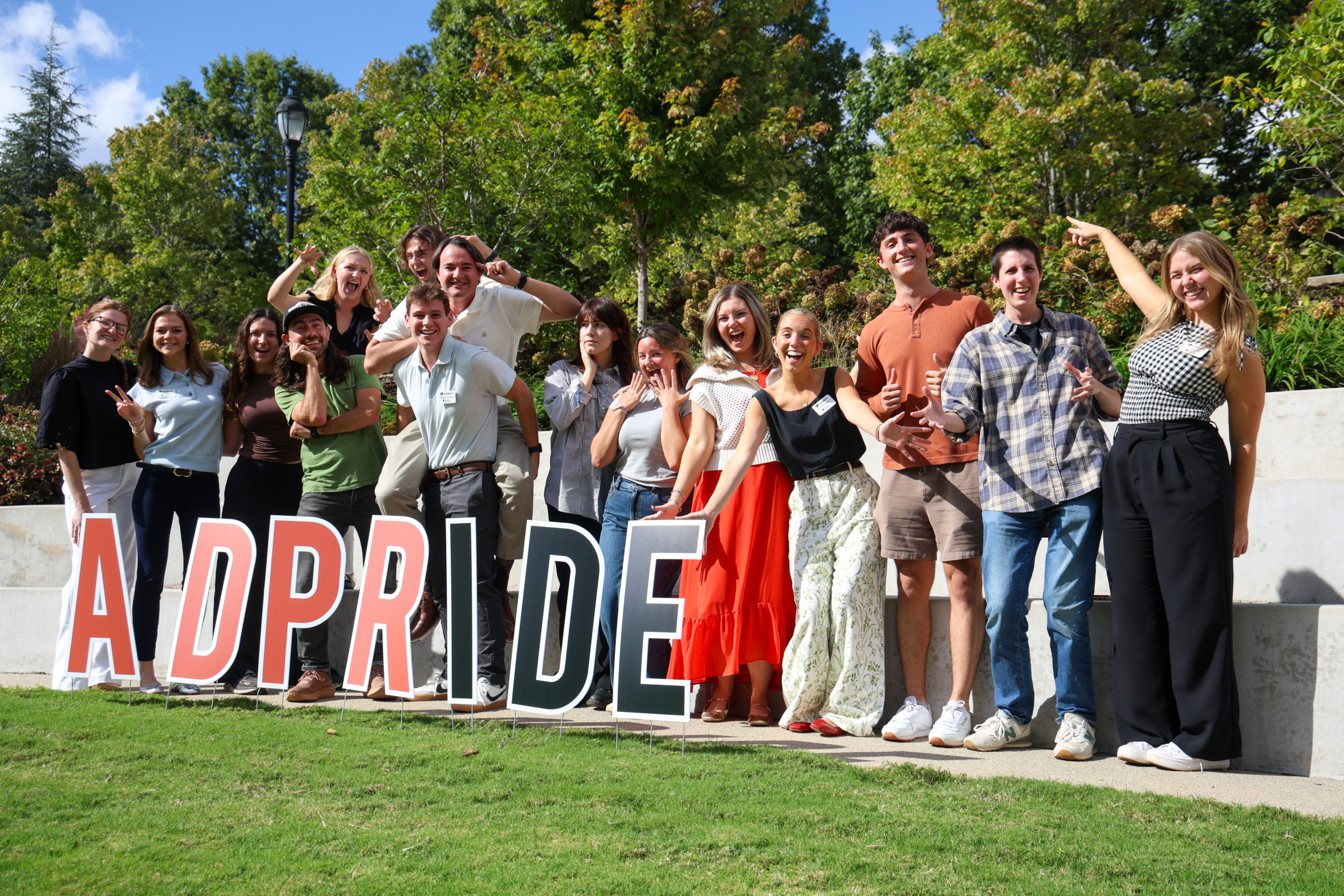 Group of smiling students by "ADPRIDE" letters.