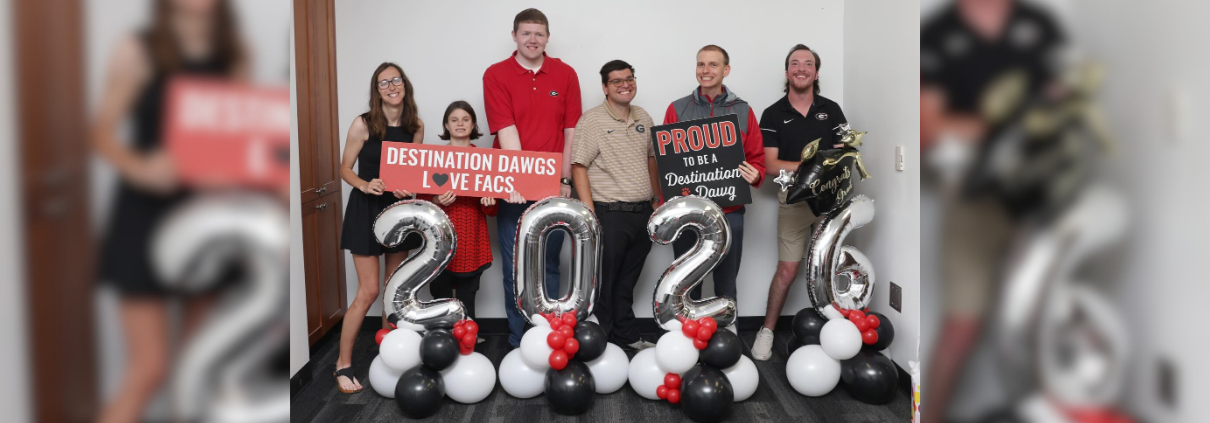 Six Destination Dawgs participants pose with celebratory balloons denoting their graduation in 2026.