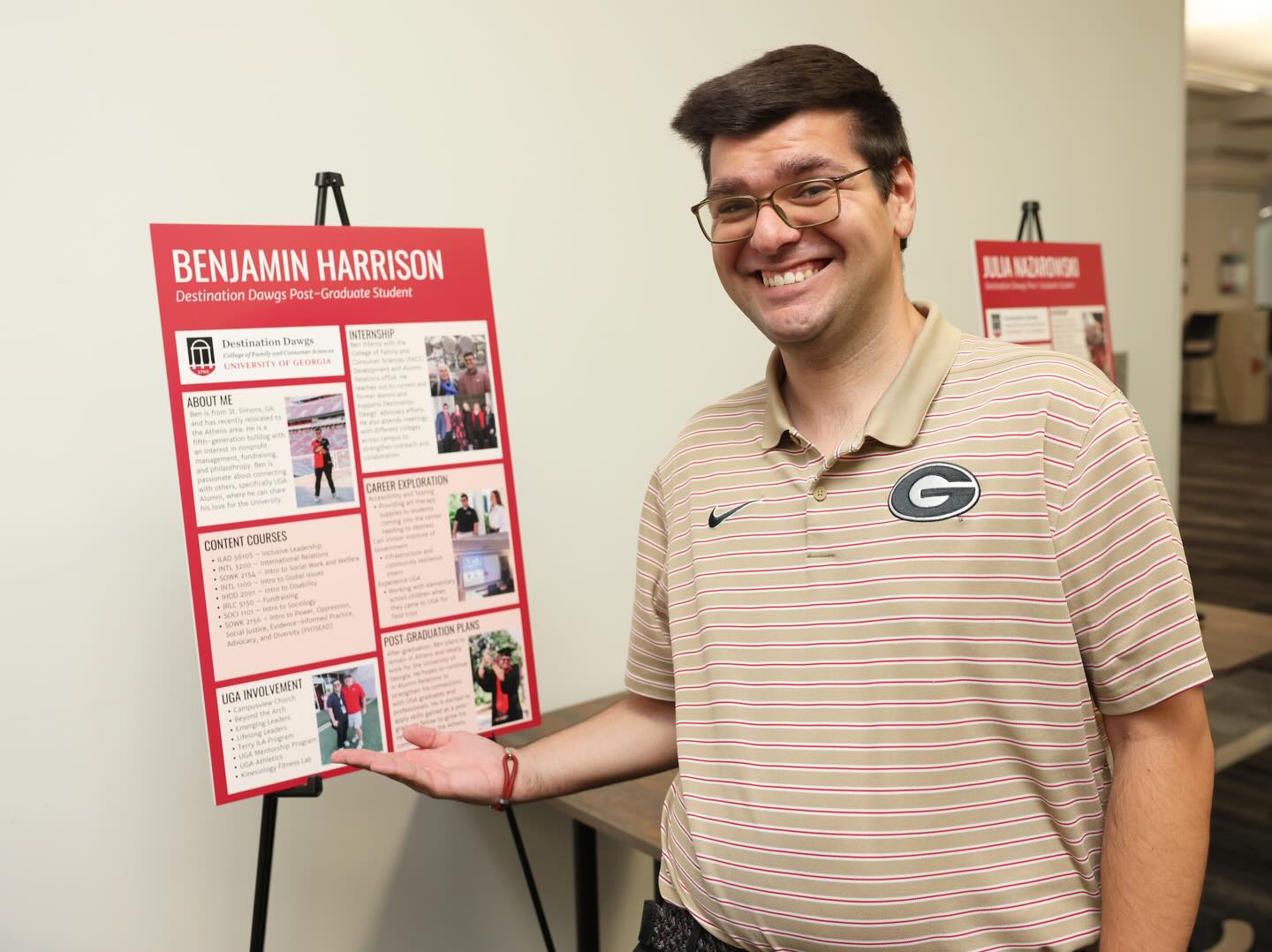 Benjamin Harrison poses next to a poster demonstrating his graduate research.
