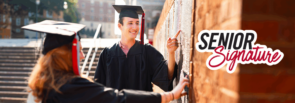 Students find their names on the Senior Signature plaque on campus.