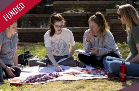 photo of social work students studying on the lawn