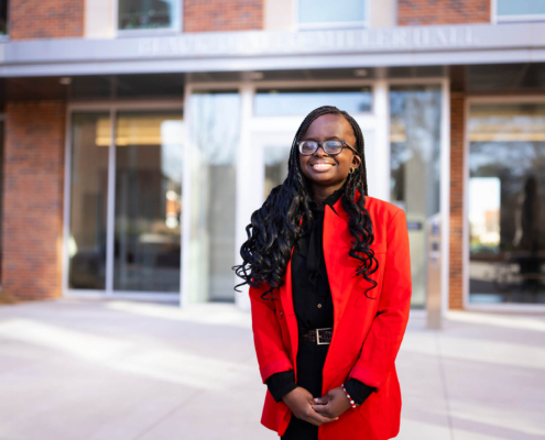 Fatime Niane, recipient of a UGA need-based scholarship, in front of Black-Diallo-Miller Hall
