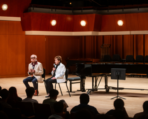 Fred and Dinah Gretsch pictured on a stage speaking to campers in Athens.