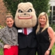 Danelle (right) and her sister, Danette (left), pose with Hairy Dawg at an alumni event with the Terry College of Business.