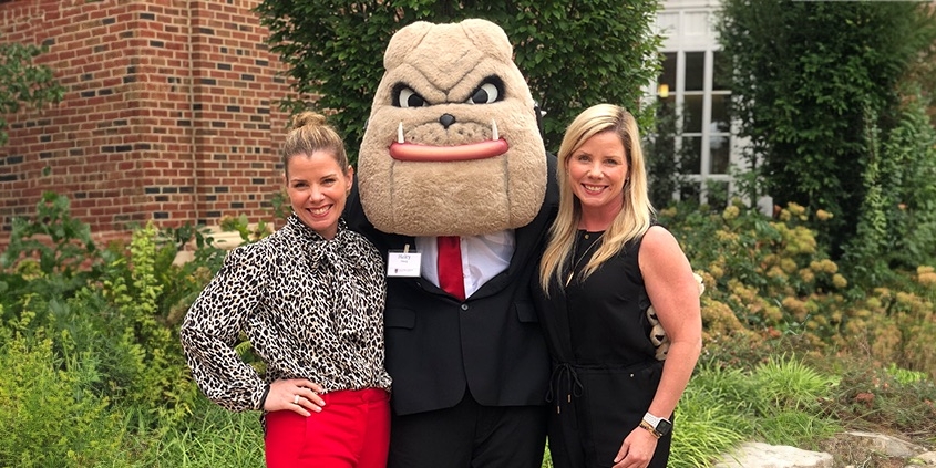 Danelle (right) and her sister, Danette (left), pose with Hairy Dawg at an alumni event with the Terry College of Business.