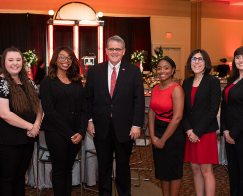 Student volunteers stand with UGA President Jere W. Morehead in the Tate Student Center Grand Ballroom before the 2022 Presidents Club Reception.