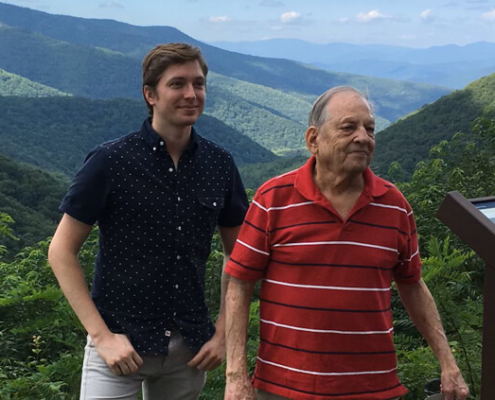 Phillip Gregory, left, stands with his uncle, Bruce Gregory, by a sign off the Blue Ridge Parkway, the design and construction of which Bruce contributed to in the 1960s.