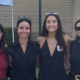 A family of six smiles for a photo outside.