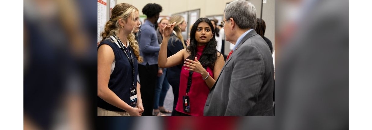 UGA President Jere Morehead speaks with two undergraduate students at the Center for Undergraduate Research 2025 Symposium.