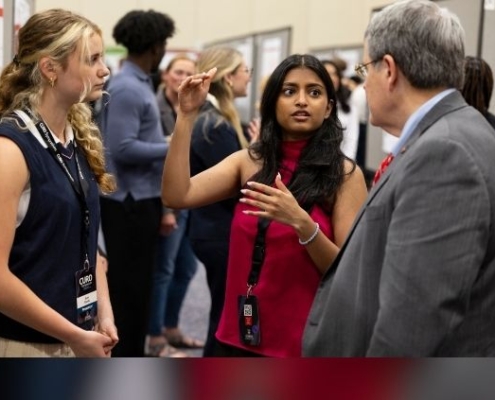 UGA President Jere Morehead speaks with two undergraduate students at the Center for Undergraduate Research 2025 Symposium.