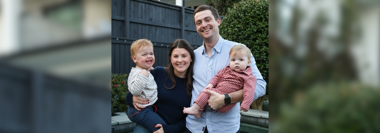 A man and woman pictured with their two young children in their arms.