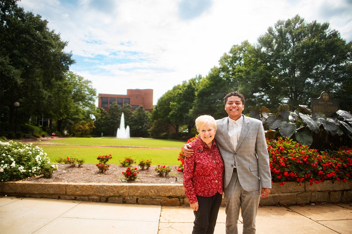 Donor Kathy Hoard and recipient Mason Howard pose together in front of Herty Field on campus.