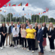 Global Externship students pose in front of a NATO building with a FUNDED banner overlayed