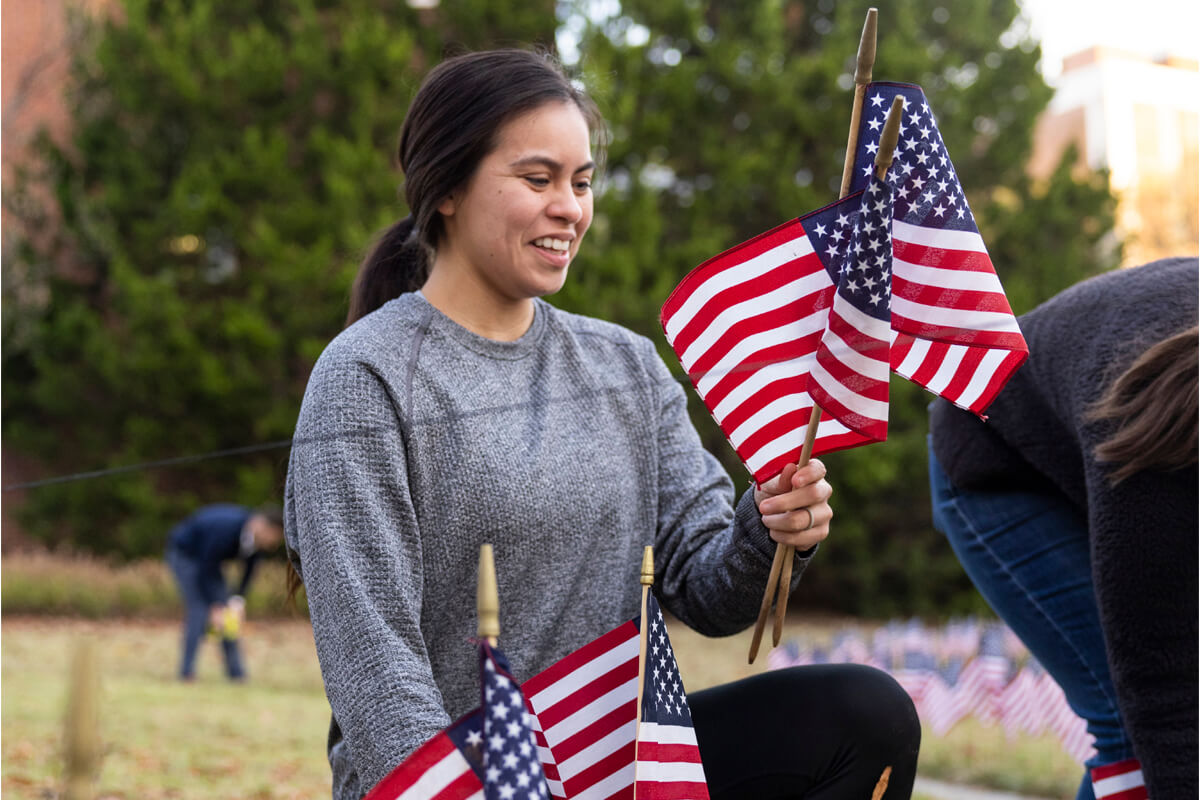 Gabriela Castillo places American flags in the UGA Memorial Garden.