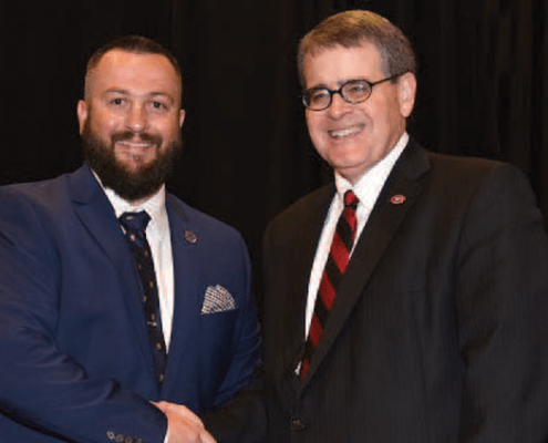 A graduating student veteran shakes hands with UGA President Jere W. Morehead at the 2019 Spring Honor Cord and Awards Reception.
