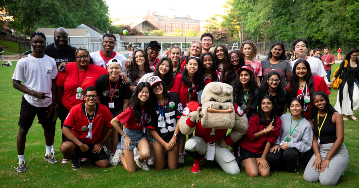 International students and Hairy Dawg pose together