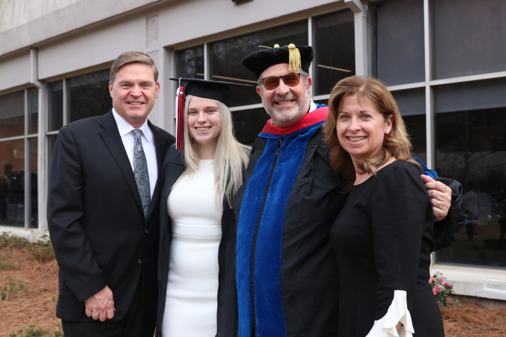 photo of the Mitchell family with Grady College Dean Charles Davis