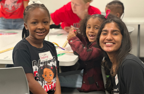 volunteer posing with two CCSD students